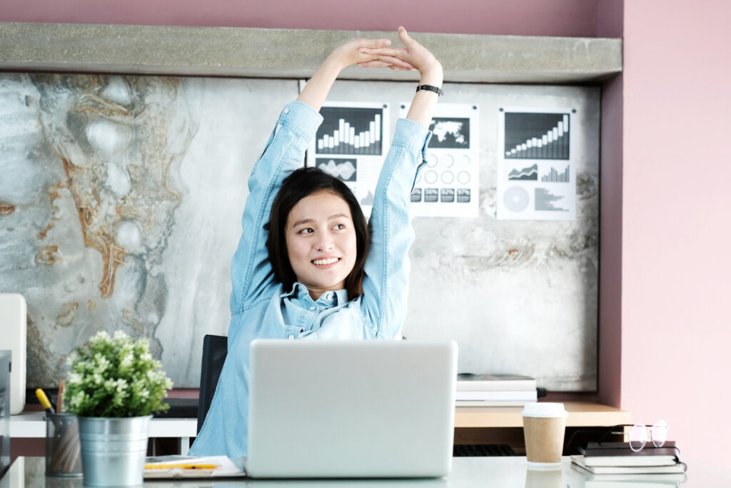 office-woman-stretching-body-for-relaxing-while-working-with-laptop-computer-at-her-desk-office-lifestyle-business-situation